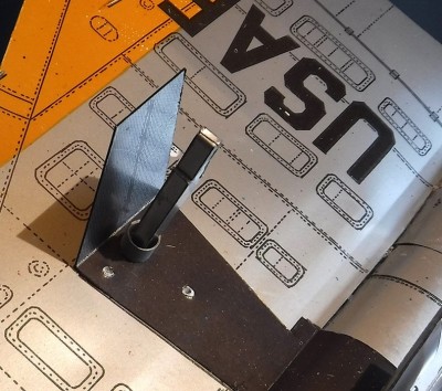 Collez la jambe du train d'atterrissage en couche épaisse et glissez un autre anneau de papier par-dessus pour plus de stabilité.