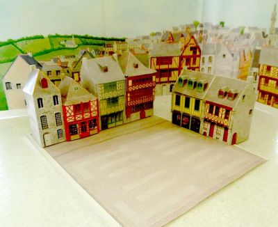 Un groupe de 4 maisons et un de 3 avec le sol pavé.
